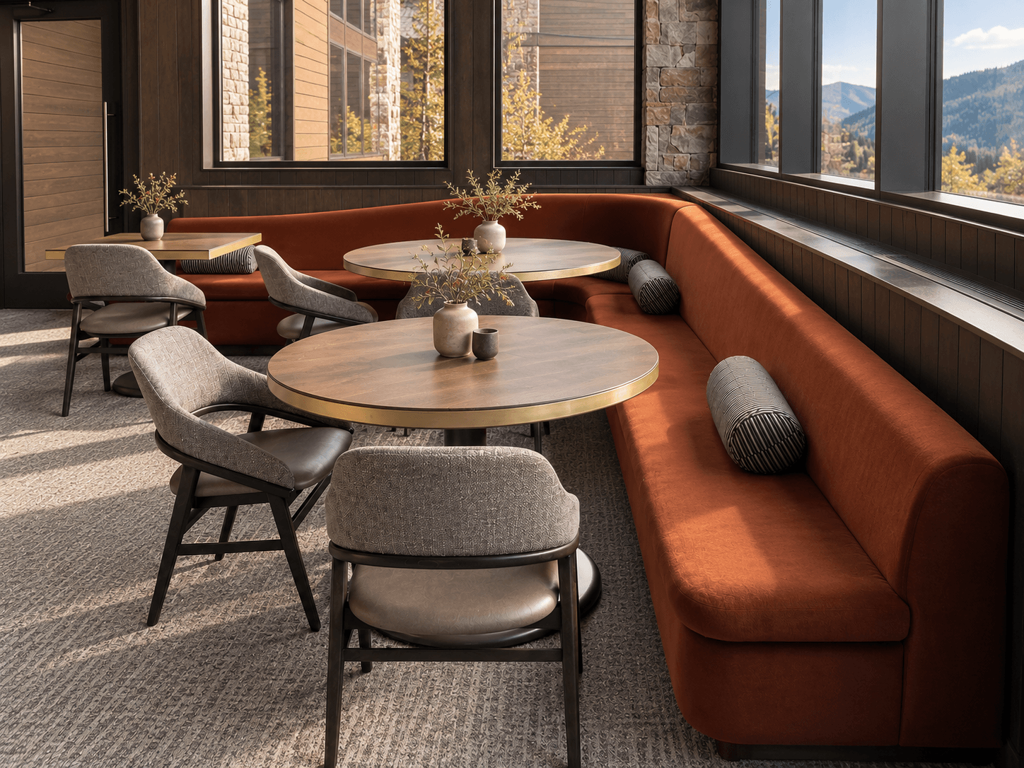 Swooping Banquette Rust-colored banquette seating beside large windows